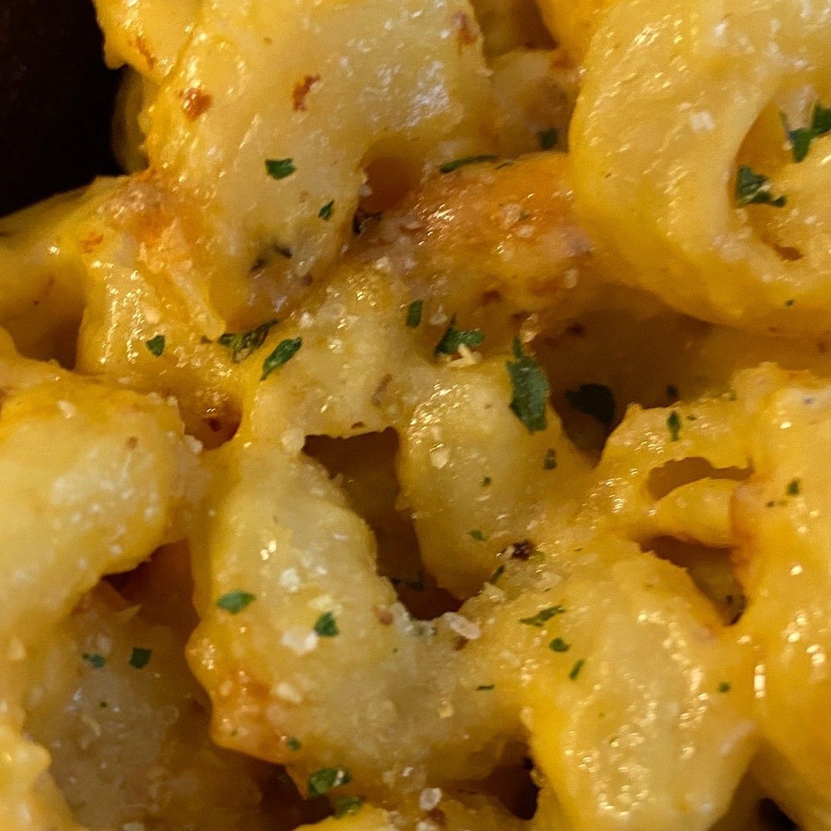 A close-up of mac and cheese with parsley on top