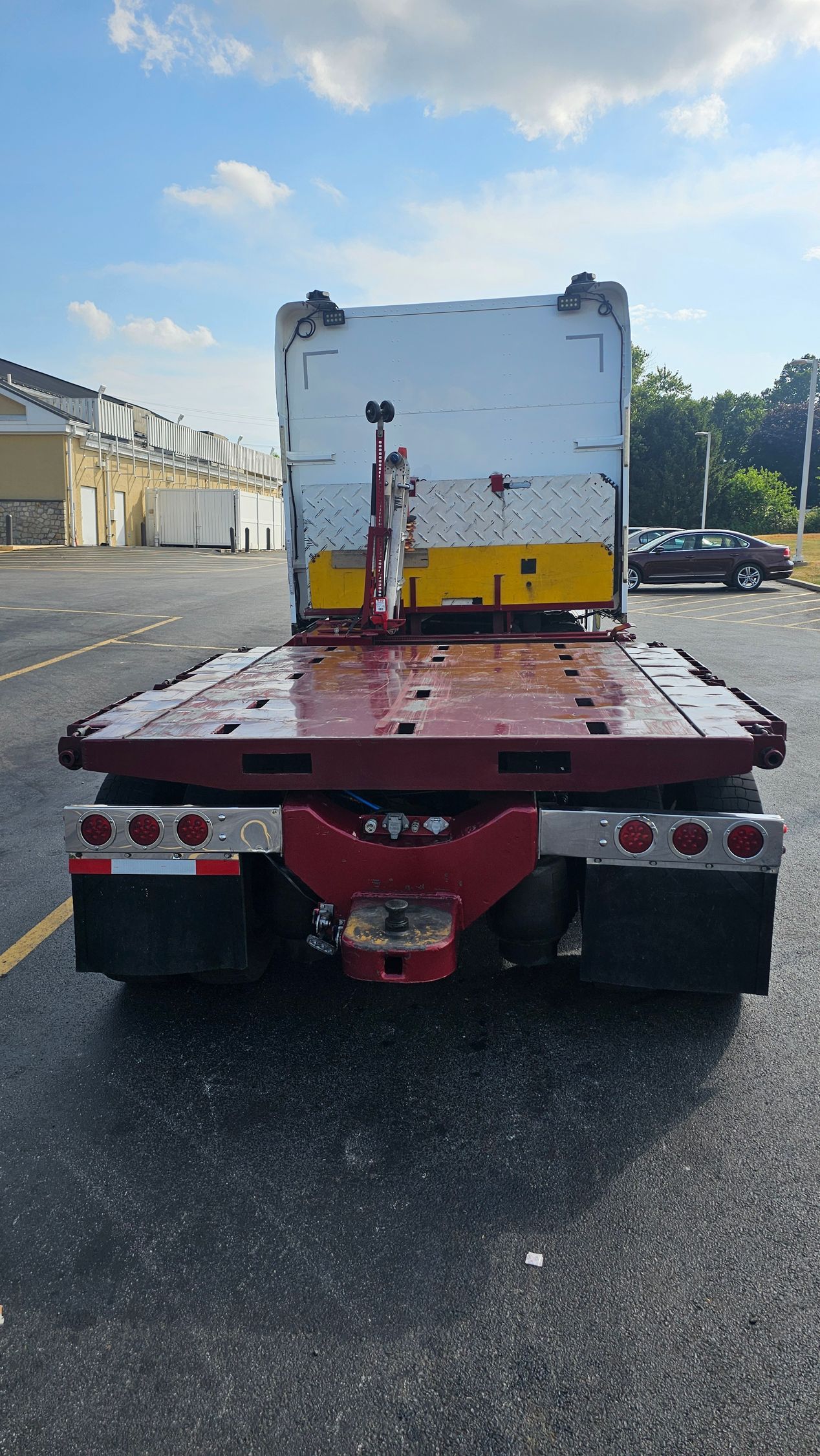 A red tow truck is parked on the side of the road.
