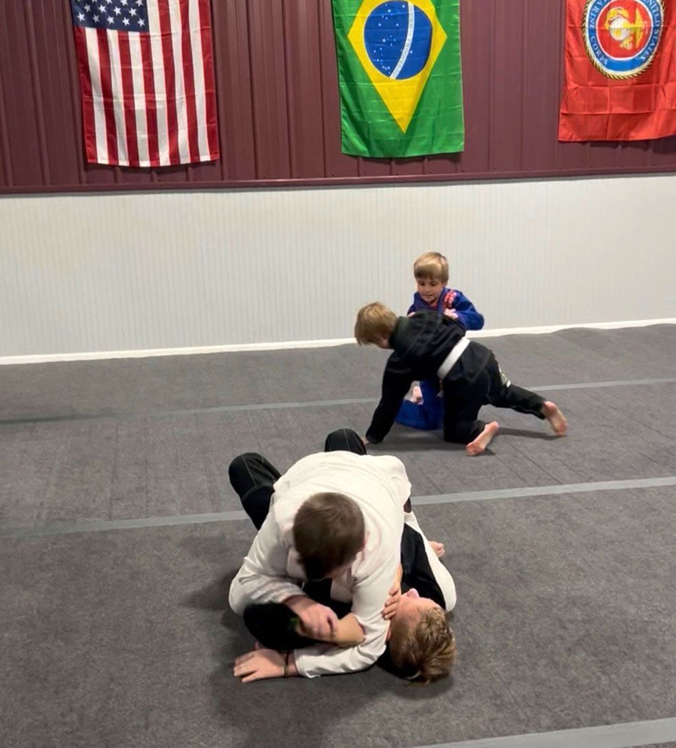 Students practicing grappling on the mat