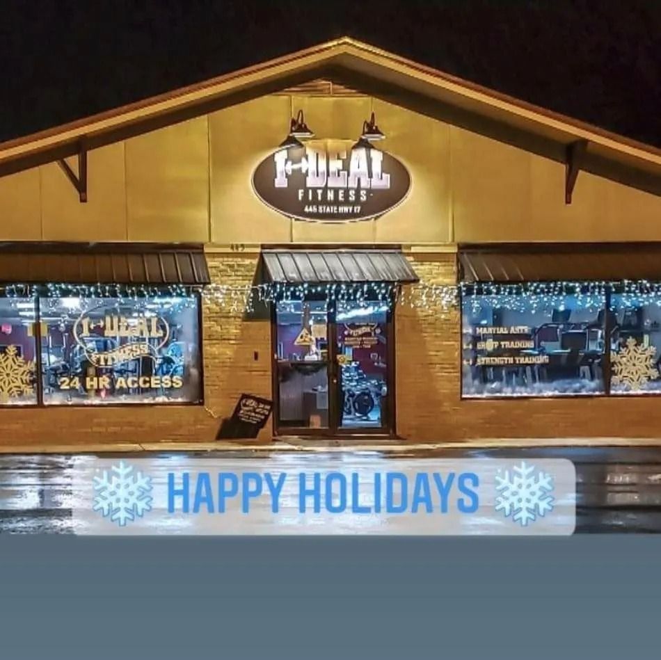 The front of a gym, Ideal Fitness, lit up for the holidays with snowflake decorations and a 
