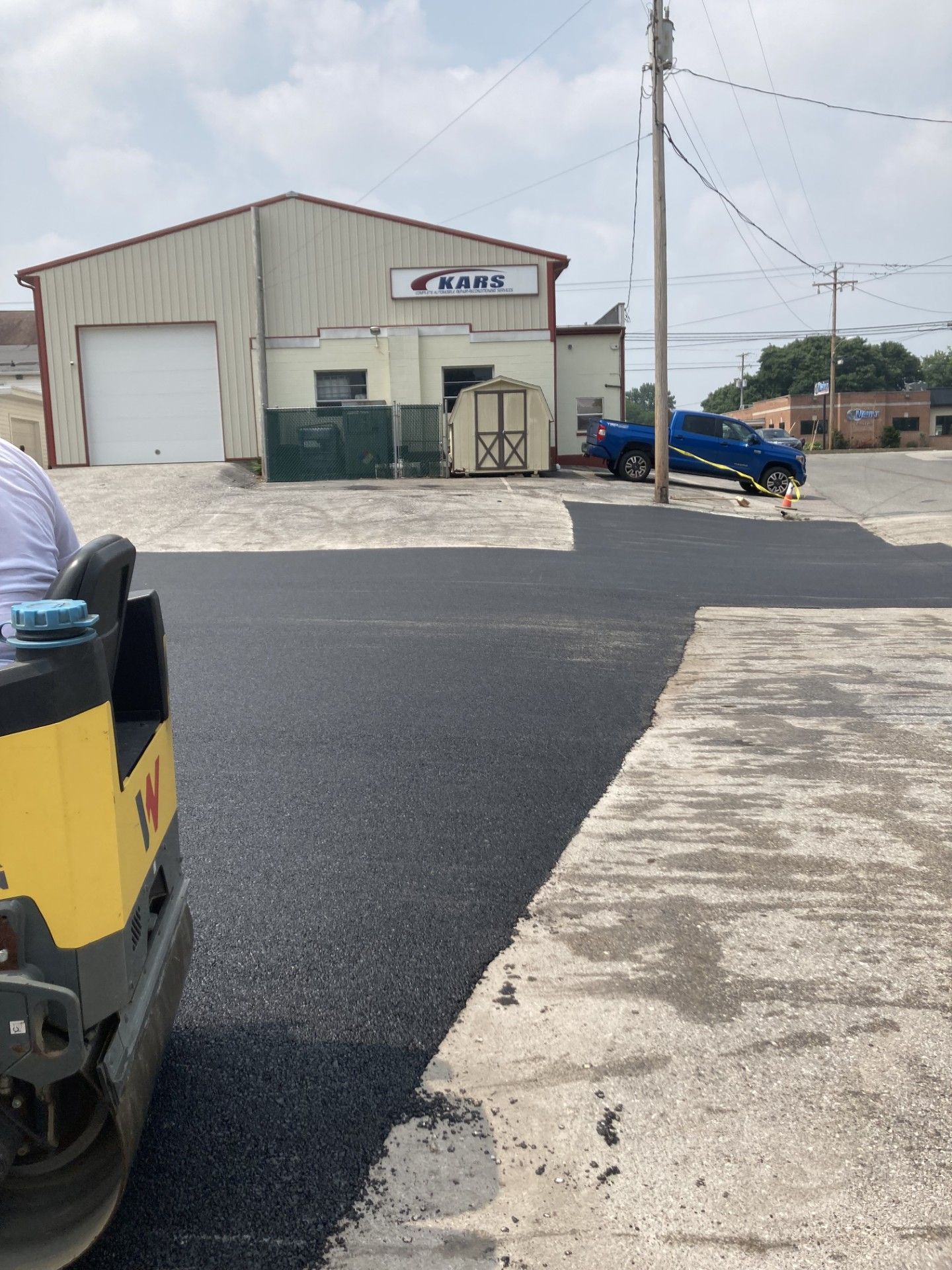 A truck is driving down a road next to a building.