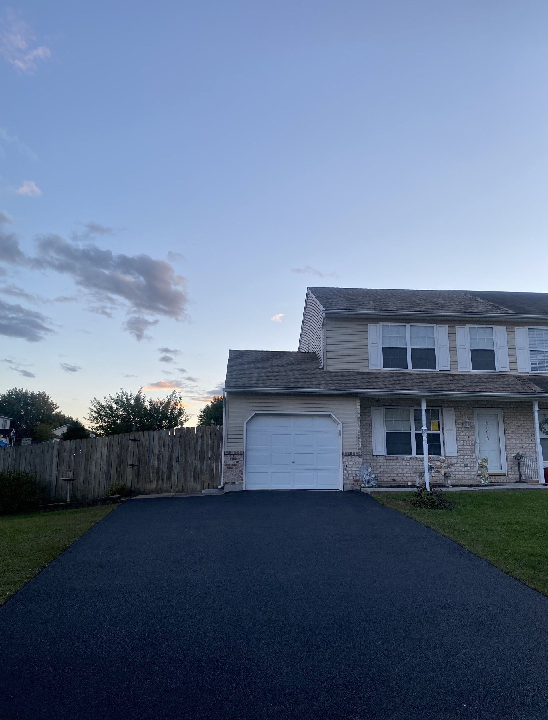 A house with a garage door and a driveway in front of it.