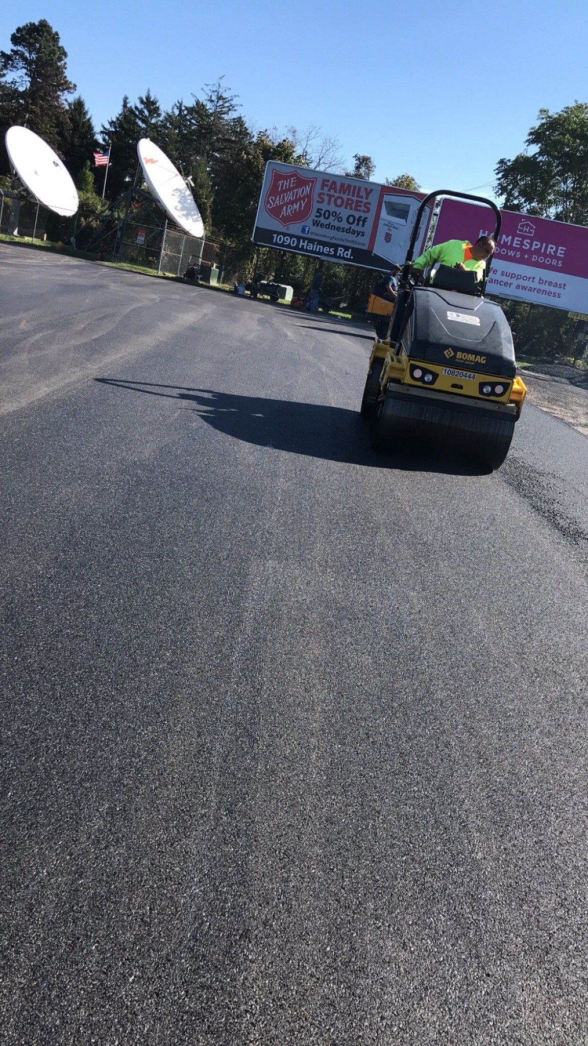 A person is driving a lawn mower down a road.