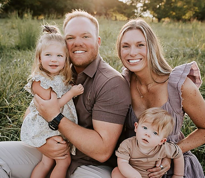 A family is posing for a picture in a field.