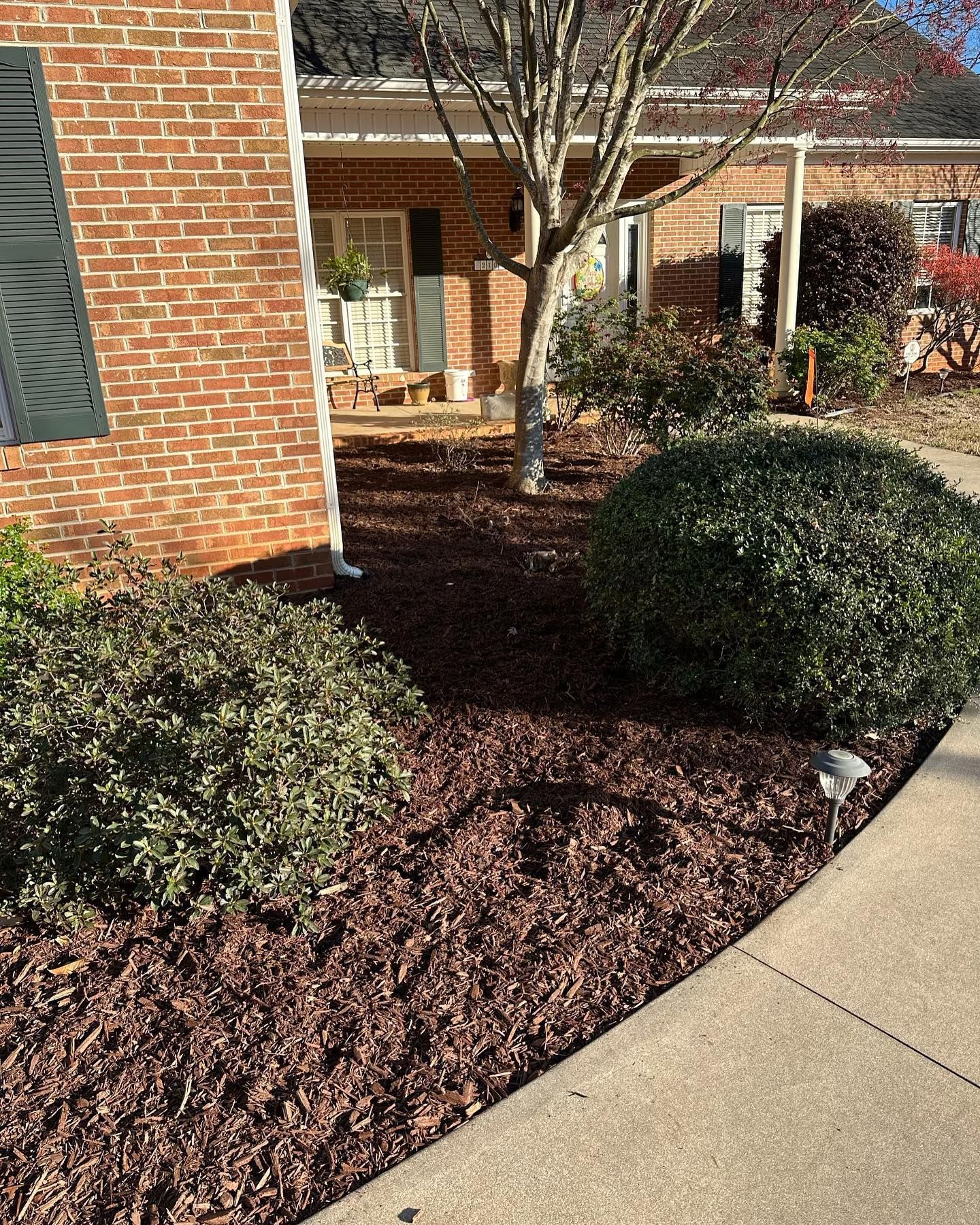 A brick house with a sidewalk in front of it.