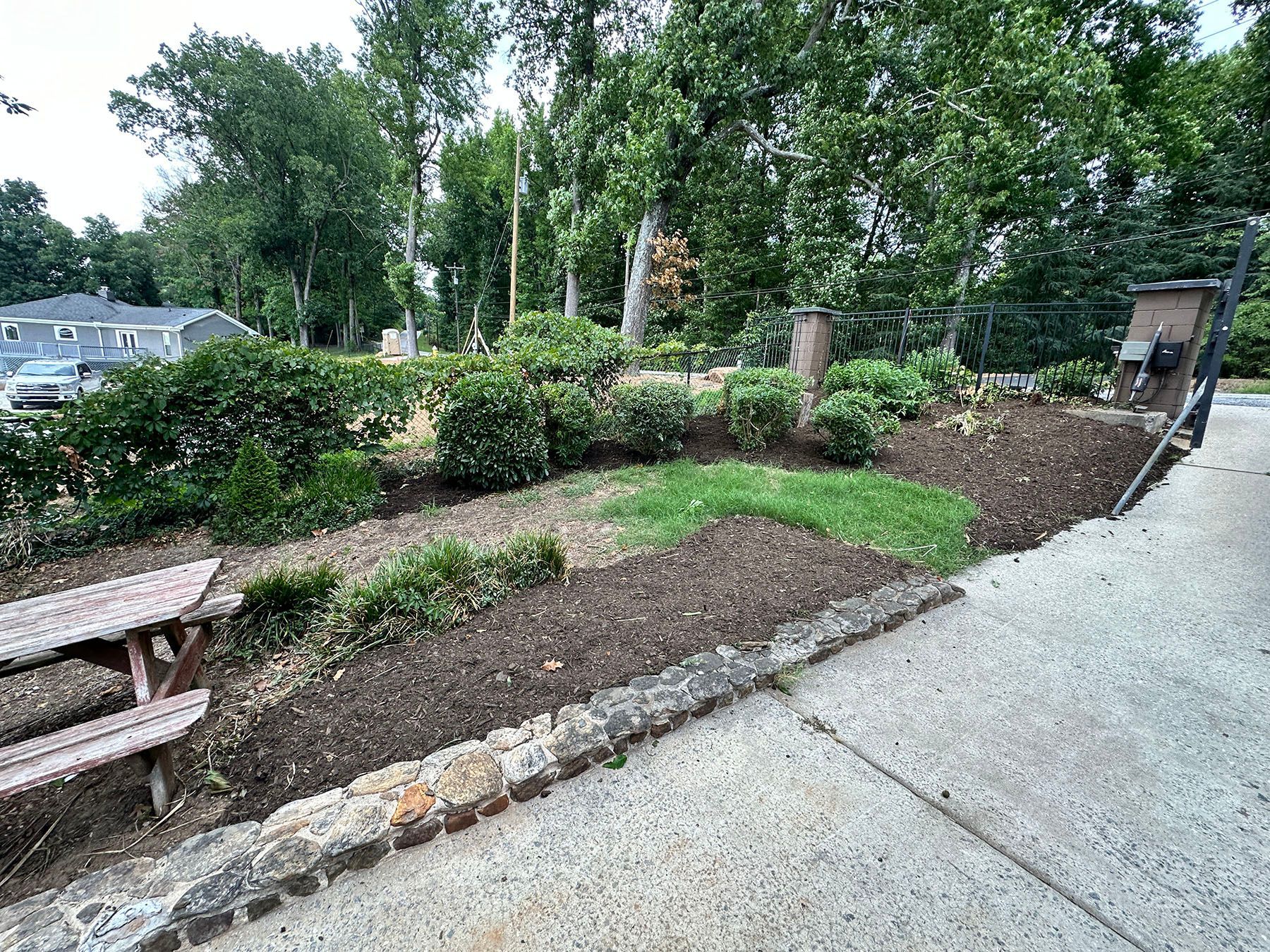 A picnic table is sitting next to a sidewalk in a park.