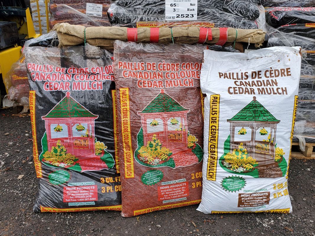 Three bags of mulch are sitting on top of each other on a pallet.
