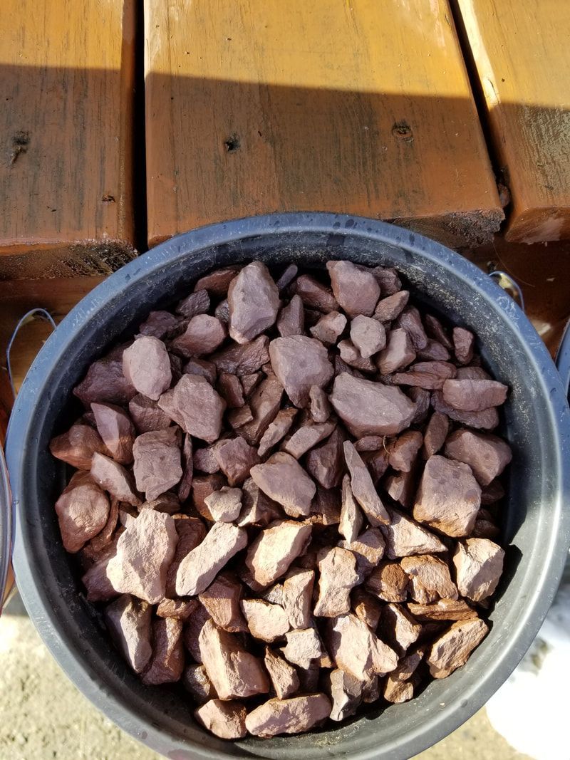 A bowl of rocks is sitting on a wooden table.