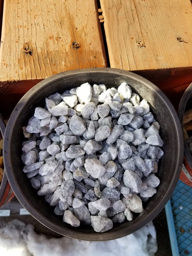 A bowl of rocks is sitting on a wooden table.
