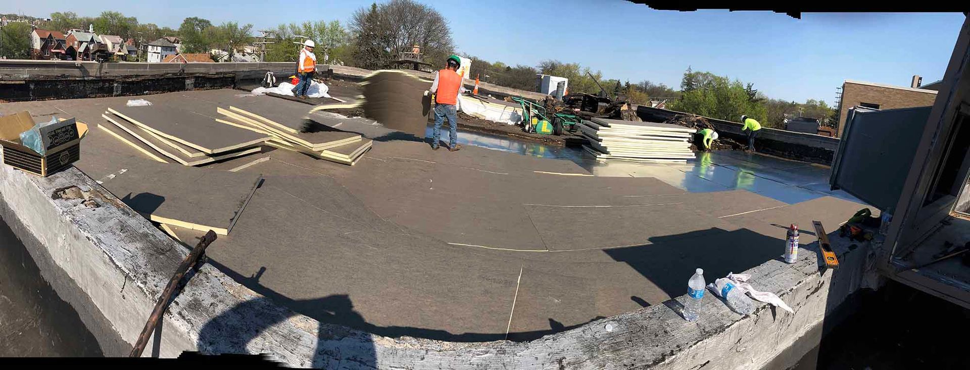 A group of construction workers are working on a roof.