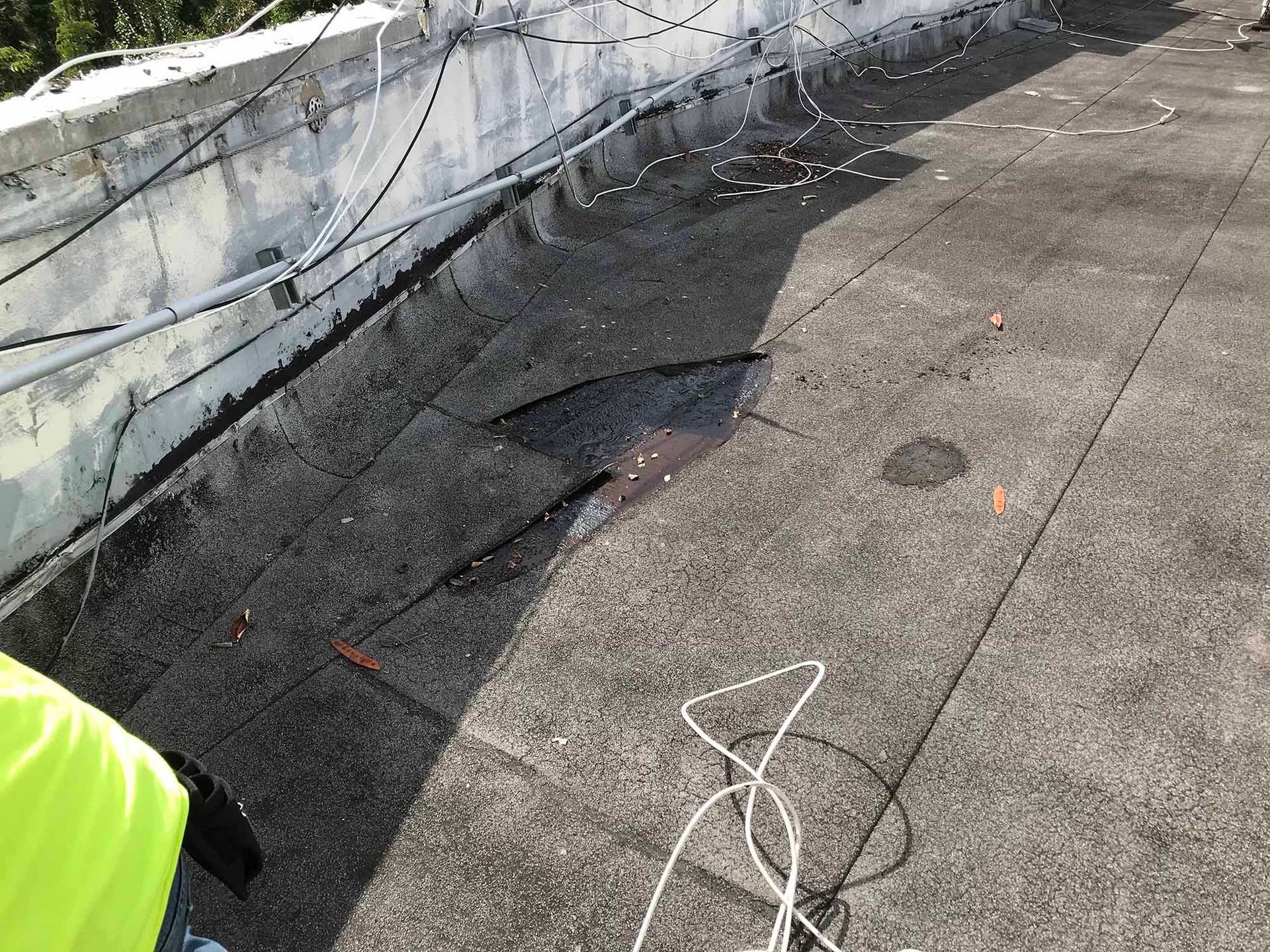 A person is standing on a roof with a hole in it.