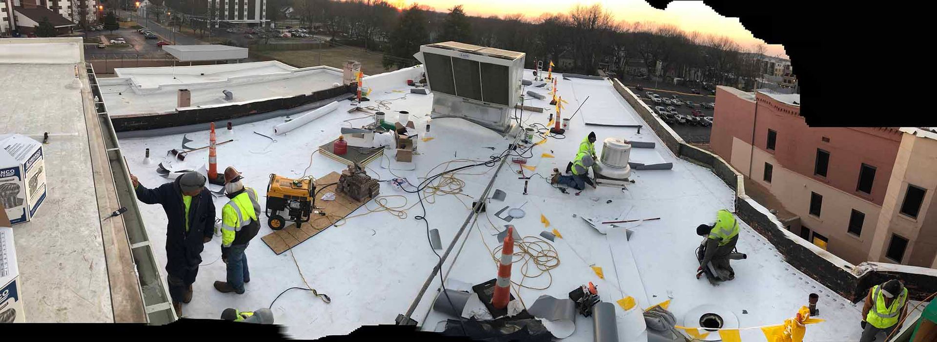 A group of construction workers are working on the roof of a building.