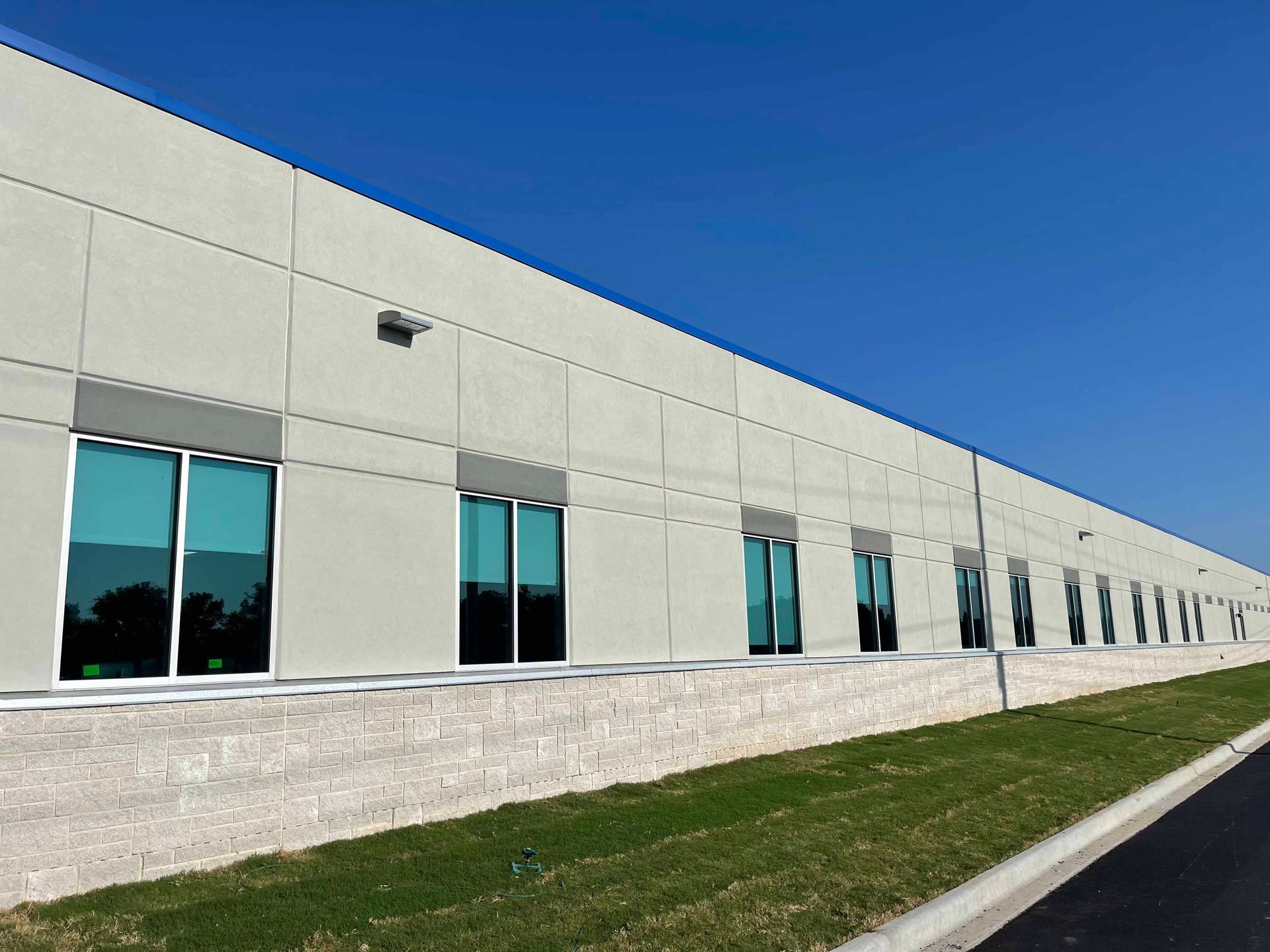 A large building with a lot of windows and a blue sky in the background
