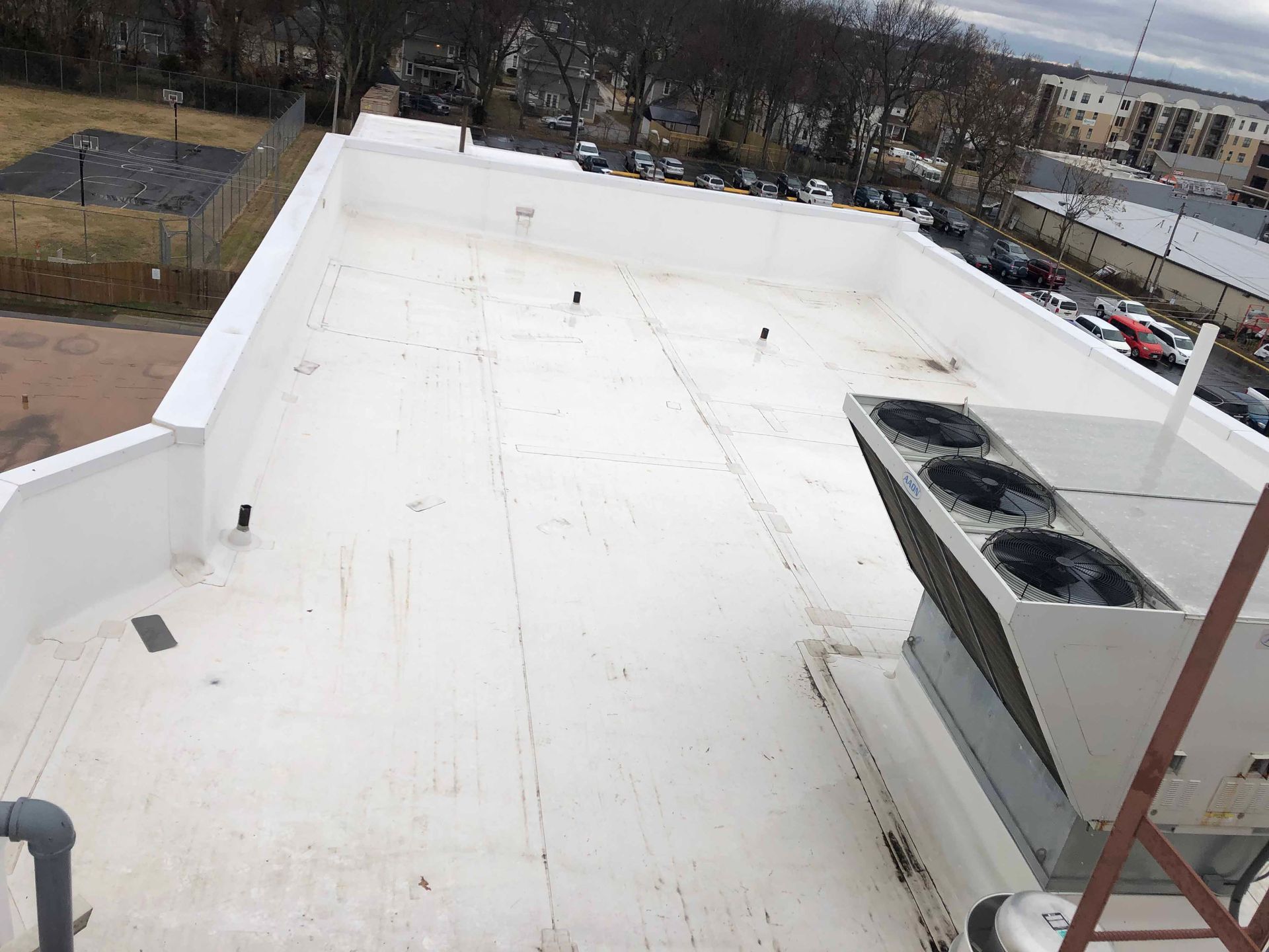 A white roof with two air conditioners on it