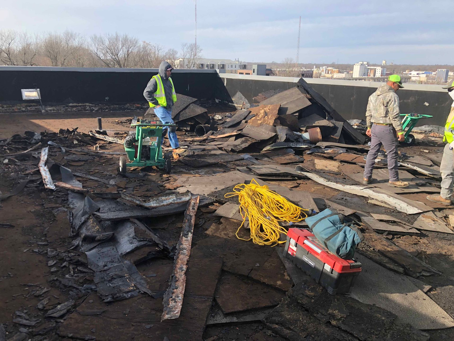 A group of construction workers are working on a roof.