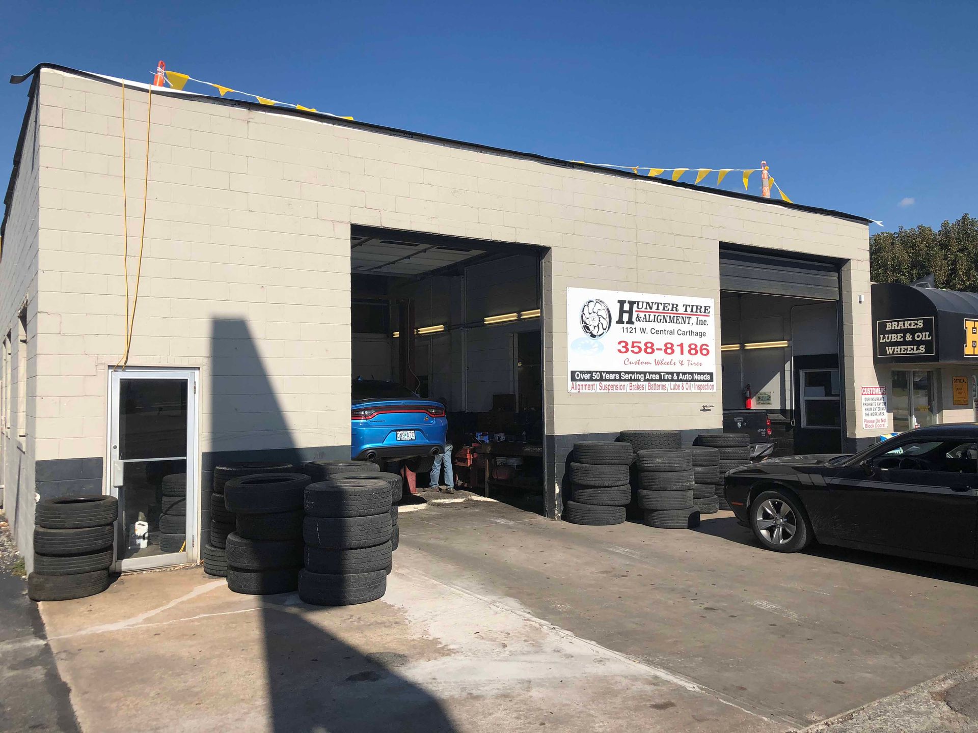 A car is parked in front of a tire shop.