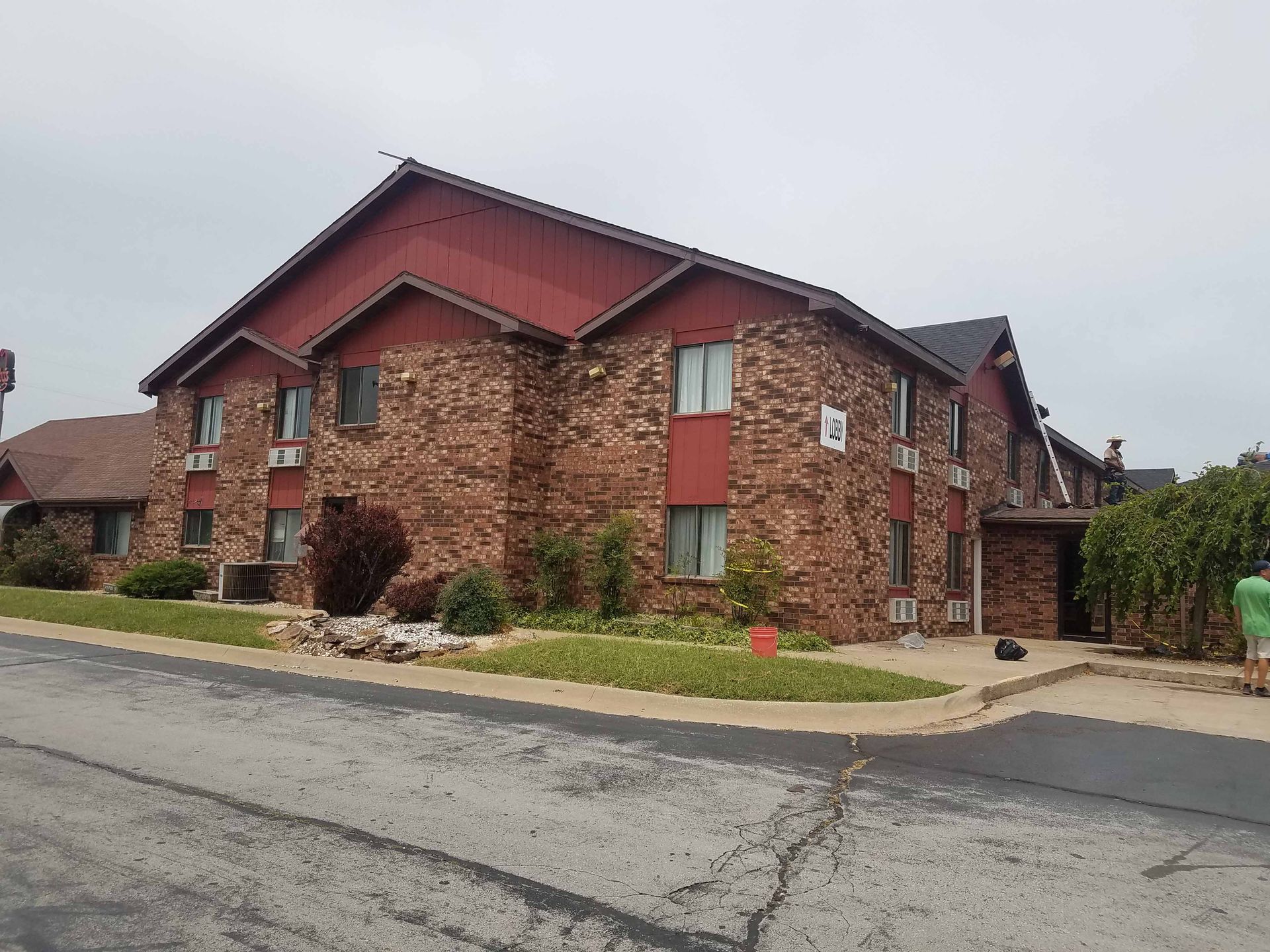 A large brick apartment building with a red roof