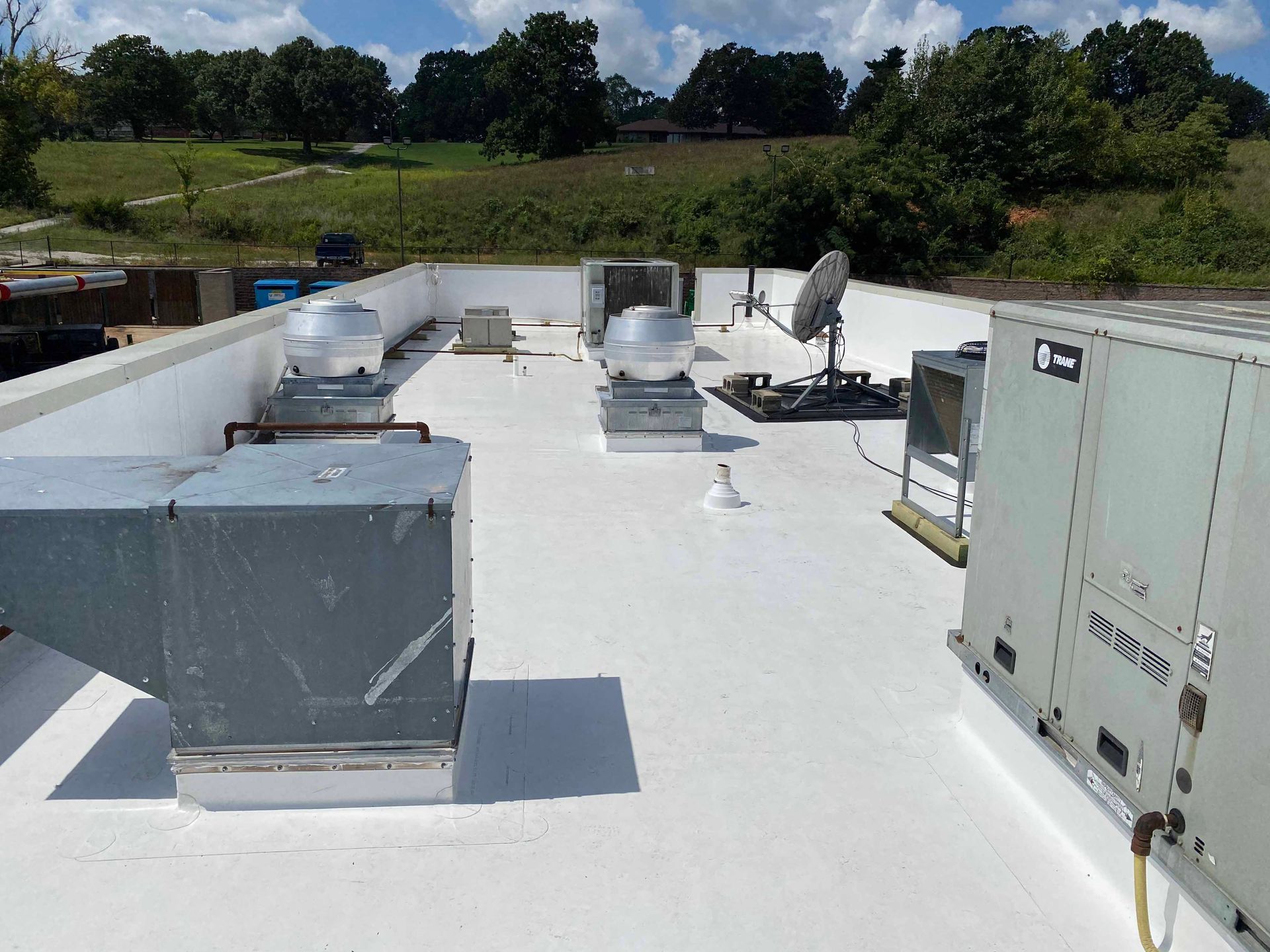 The roof of a building has a lot of air conditioning equipment on it
