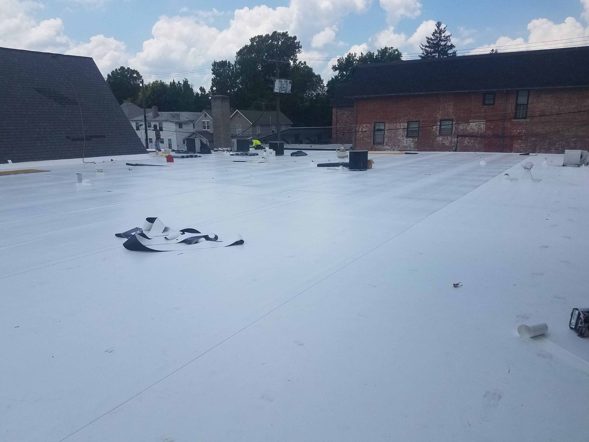 A white roof is being installed on top of a brick building.