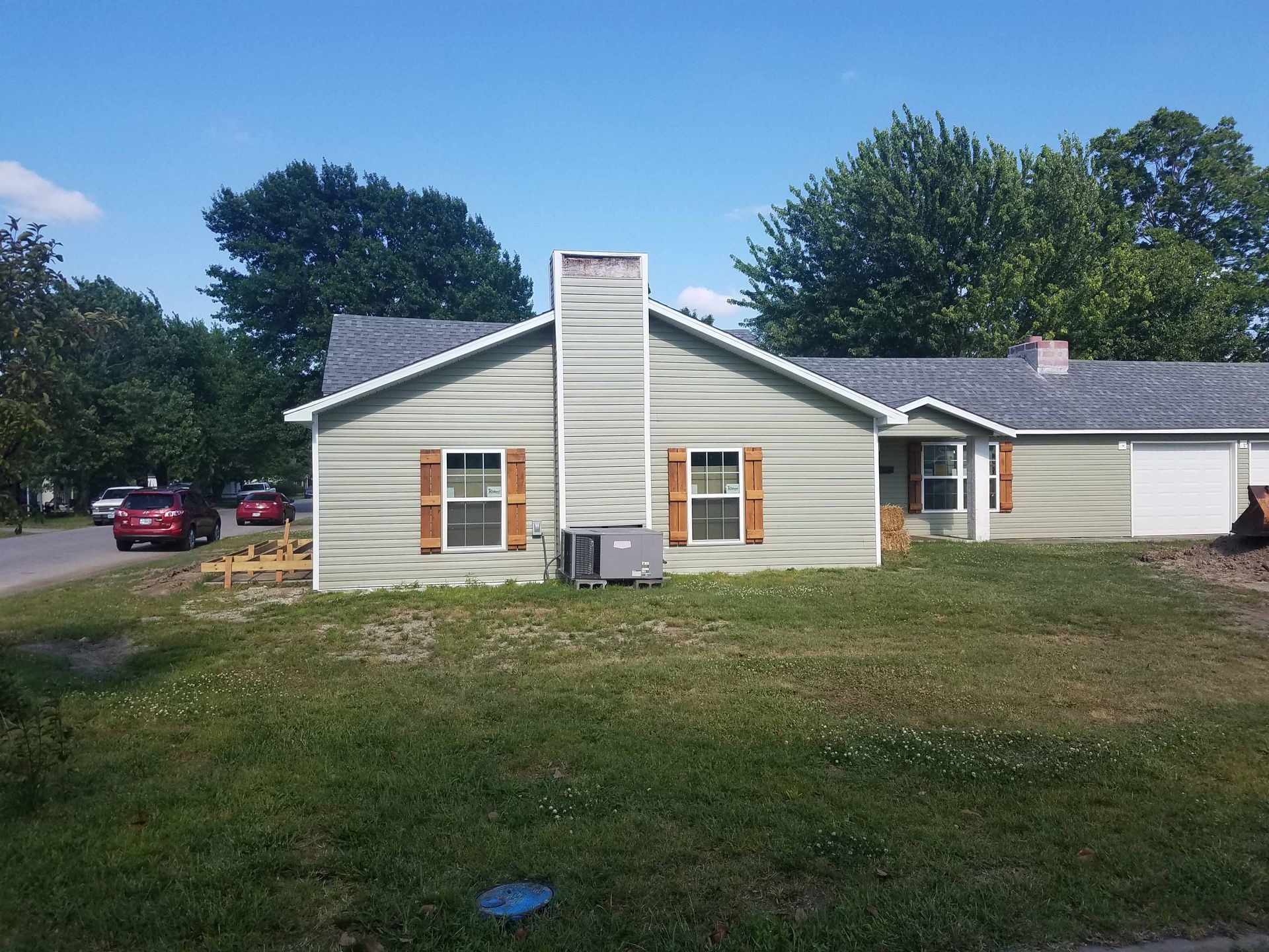 A house with a gray roof and green siding