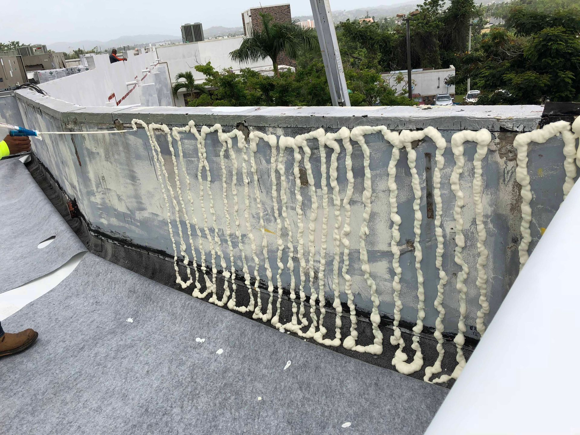 A bunch of white foam is hanging from a rope on the side of a building.