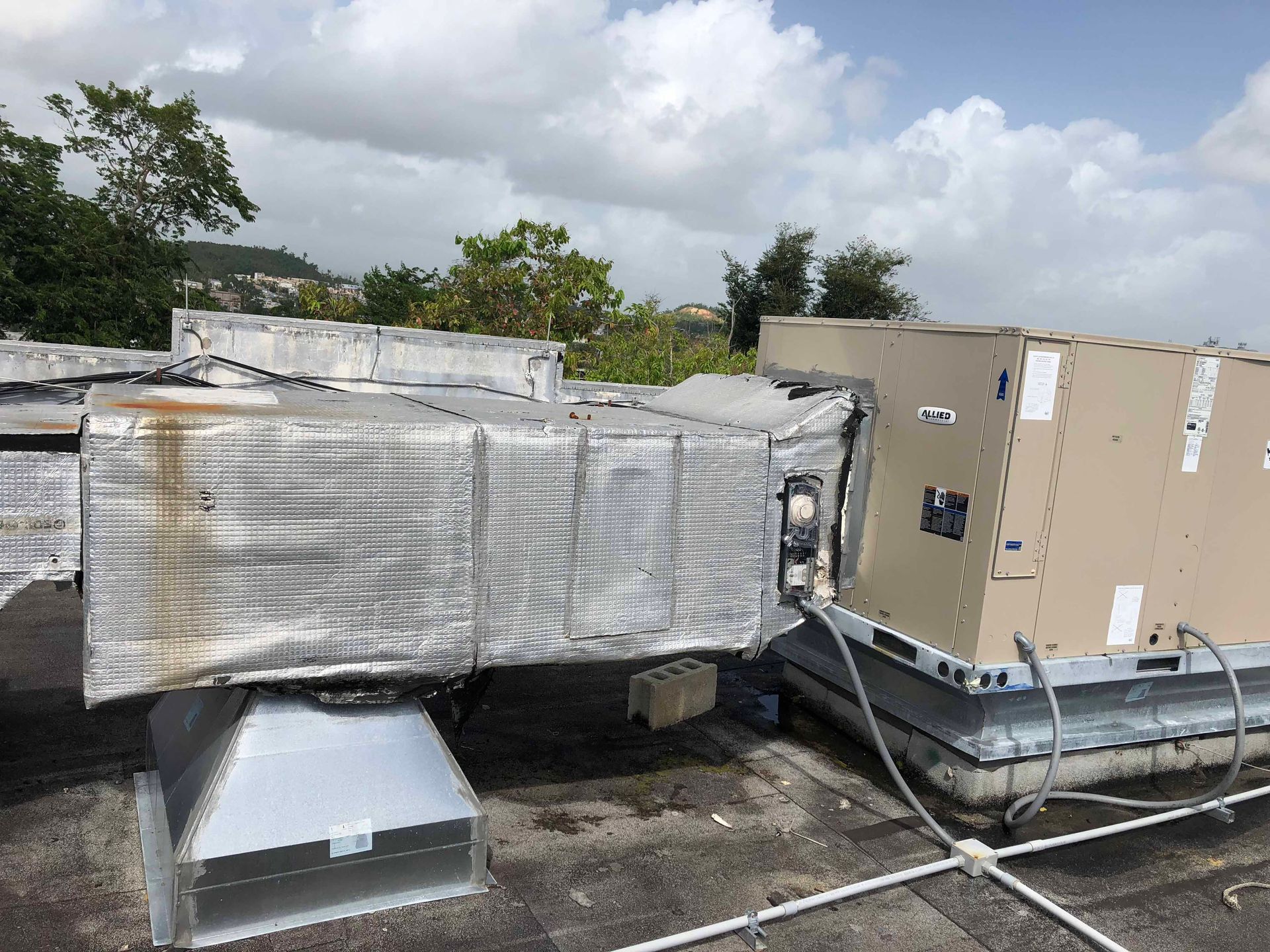 A large air conditioner is sitting on top of a roof.