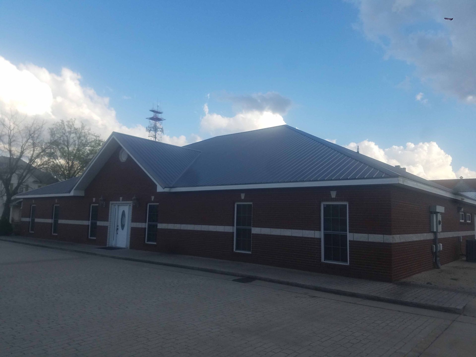 A small brick building with a metal roof