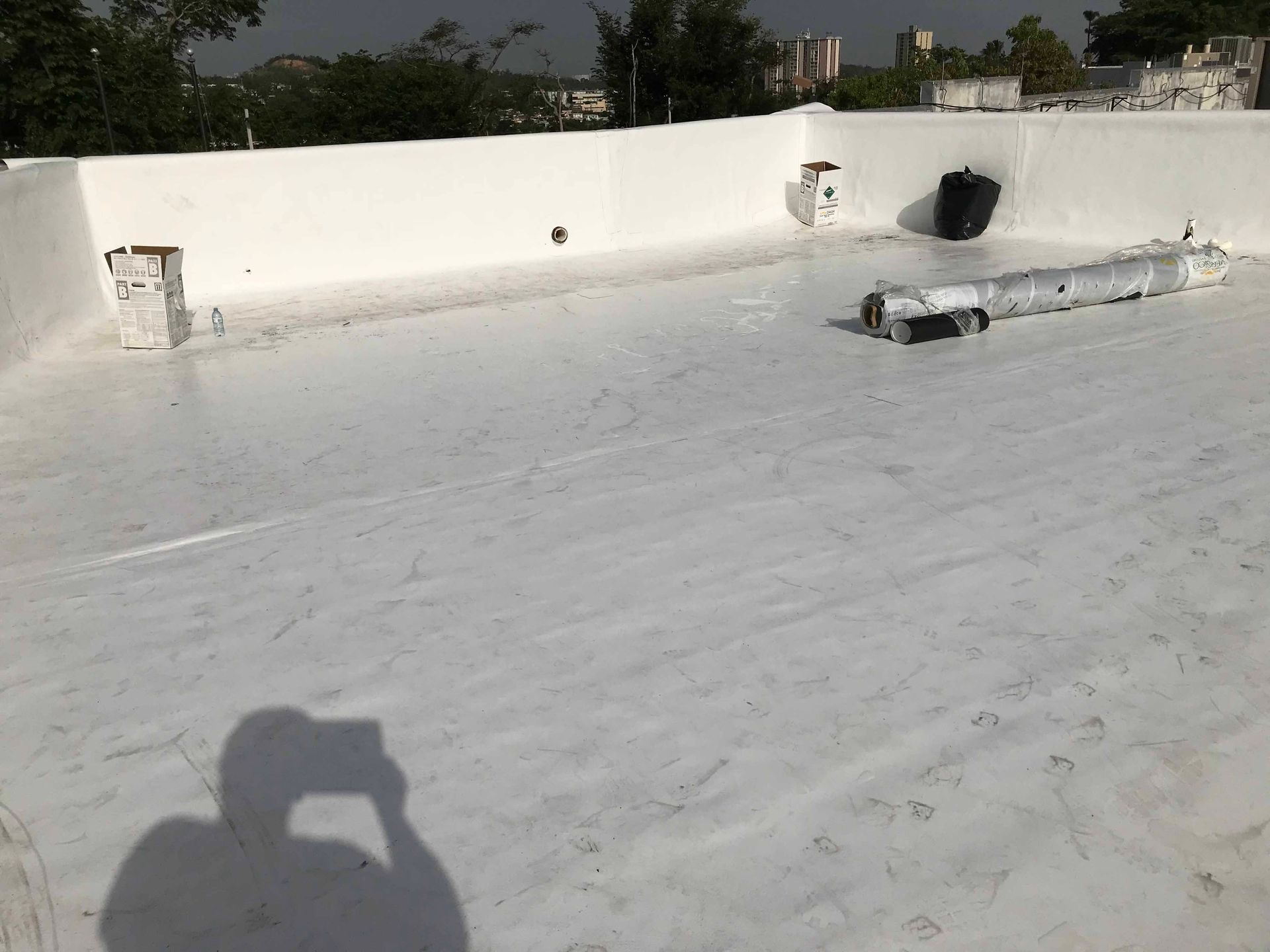 A person is taking a picture of a white roof.