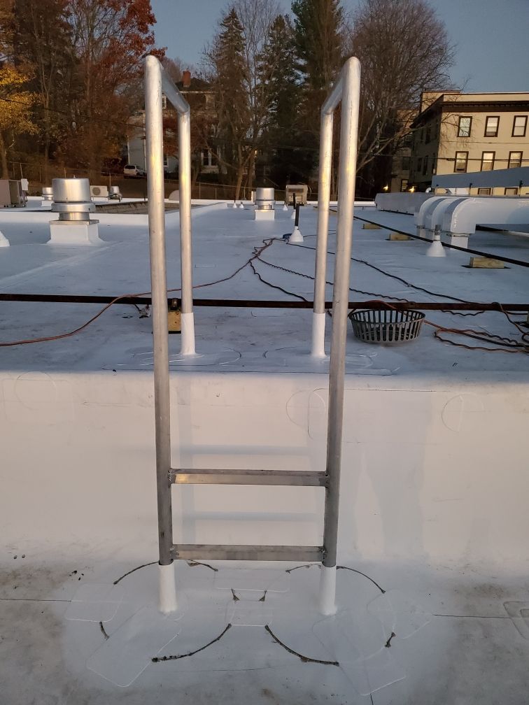A ladder is sitting on top of a white roof.