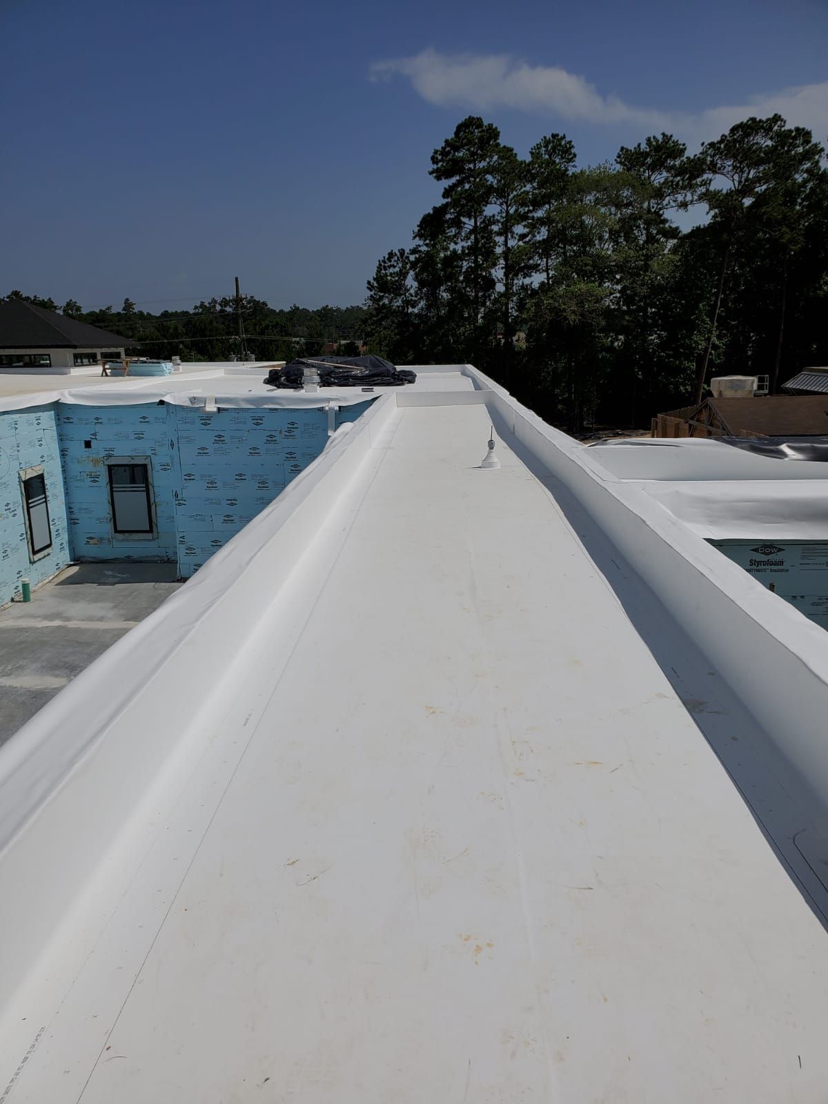 A white roof with trees in the background