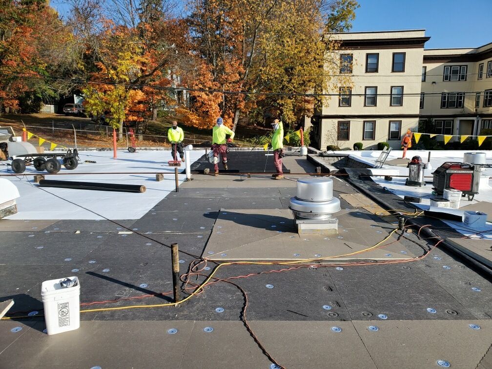 A group of men are working on the roof of a building