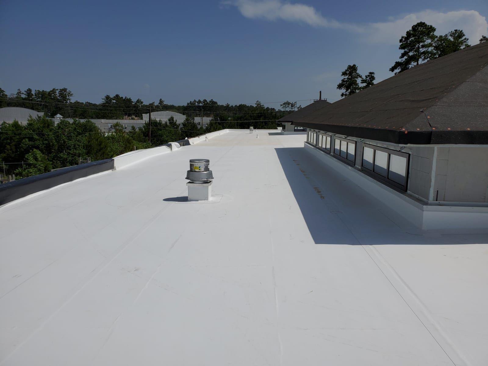 A white roof with a chimney on top of it