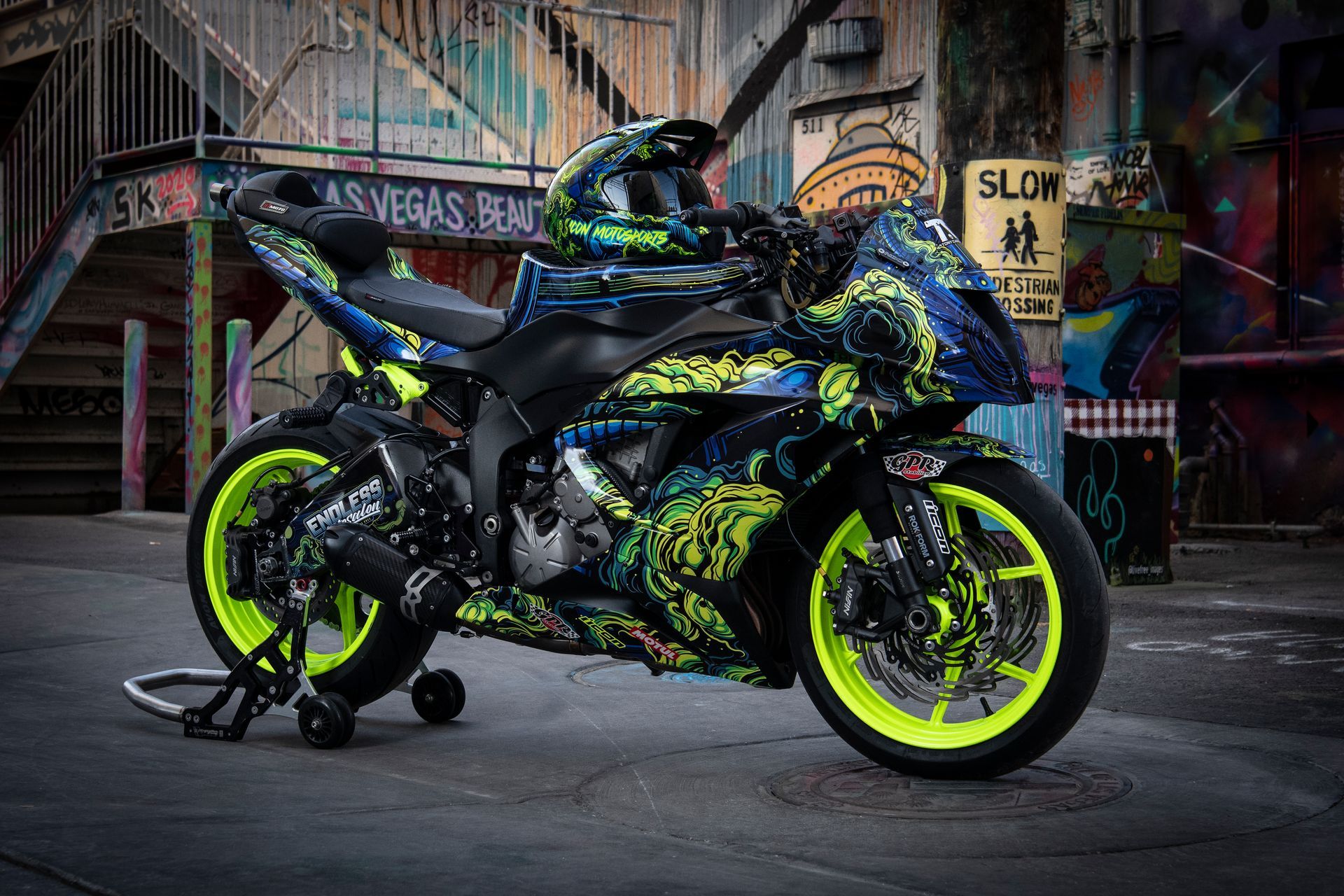 Customized sport motorcycle with neon green accents, parked in front of graffiti-covered buildings.