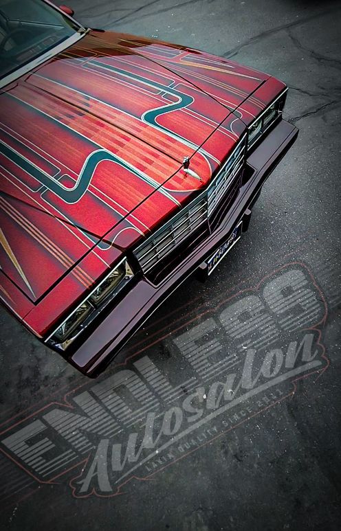 Red car hood with custom pinstripes; 