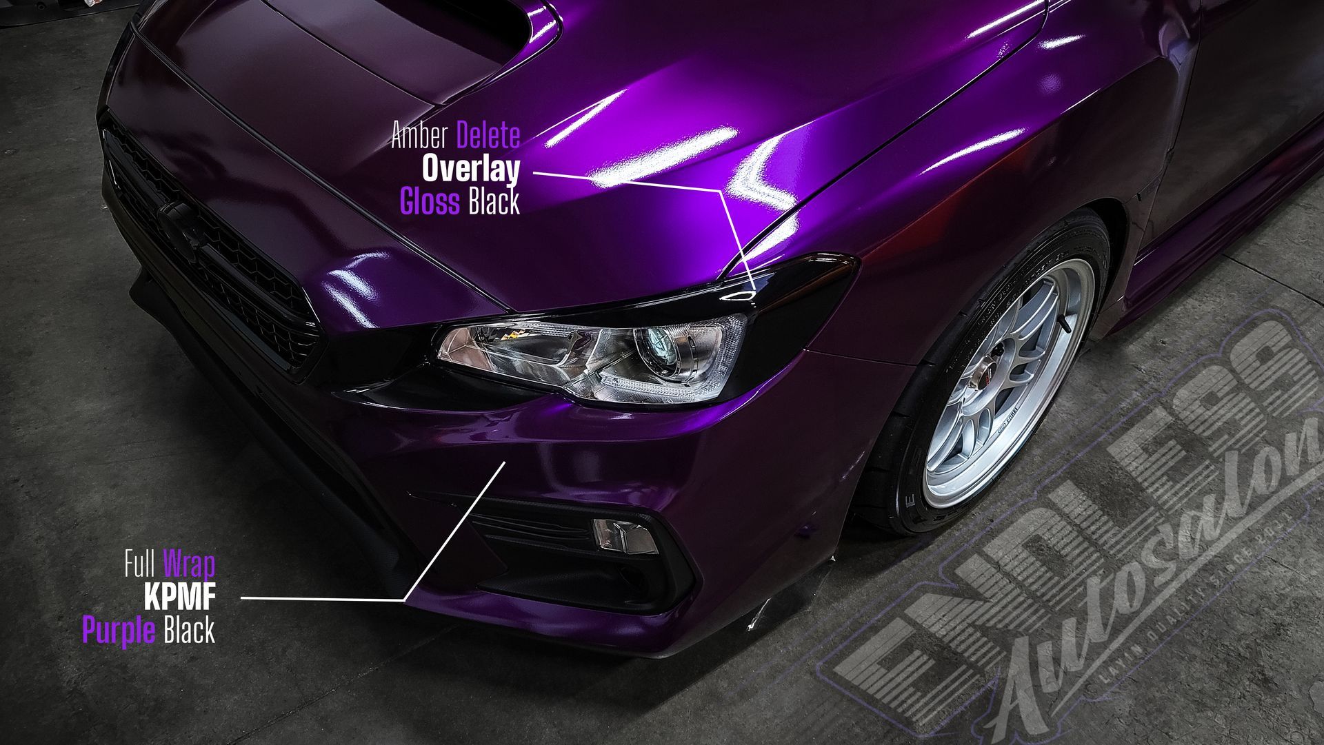 Close-up of a purple car's front with gloss black accents, parked on concrete.