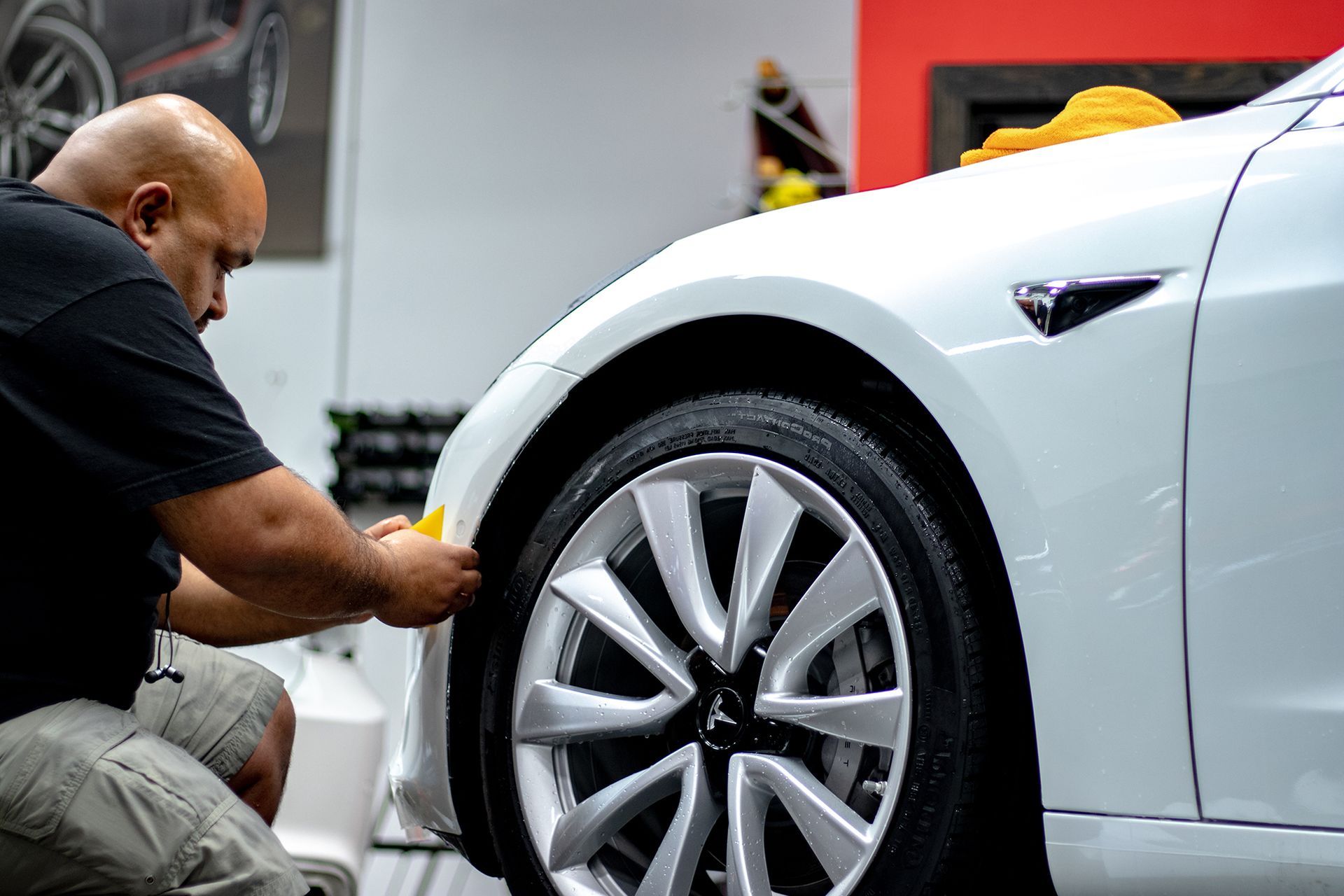 Tesla Y with a two-tone paint job: green to black. Yellow brake calipers, dark rims, parked on pavement.