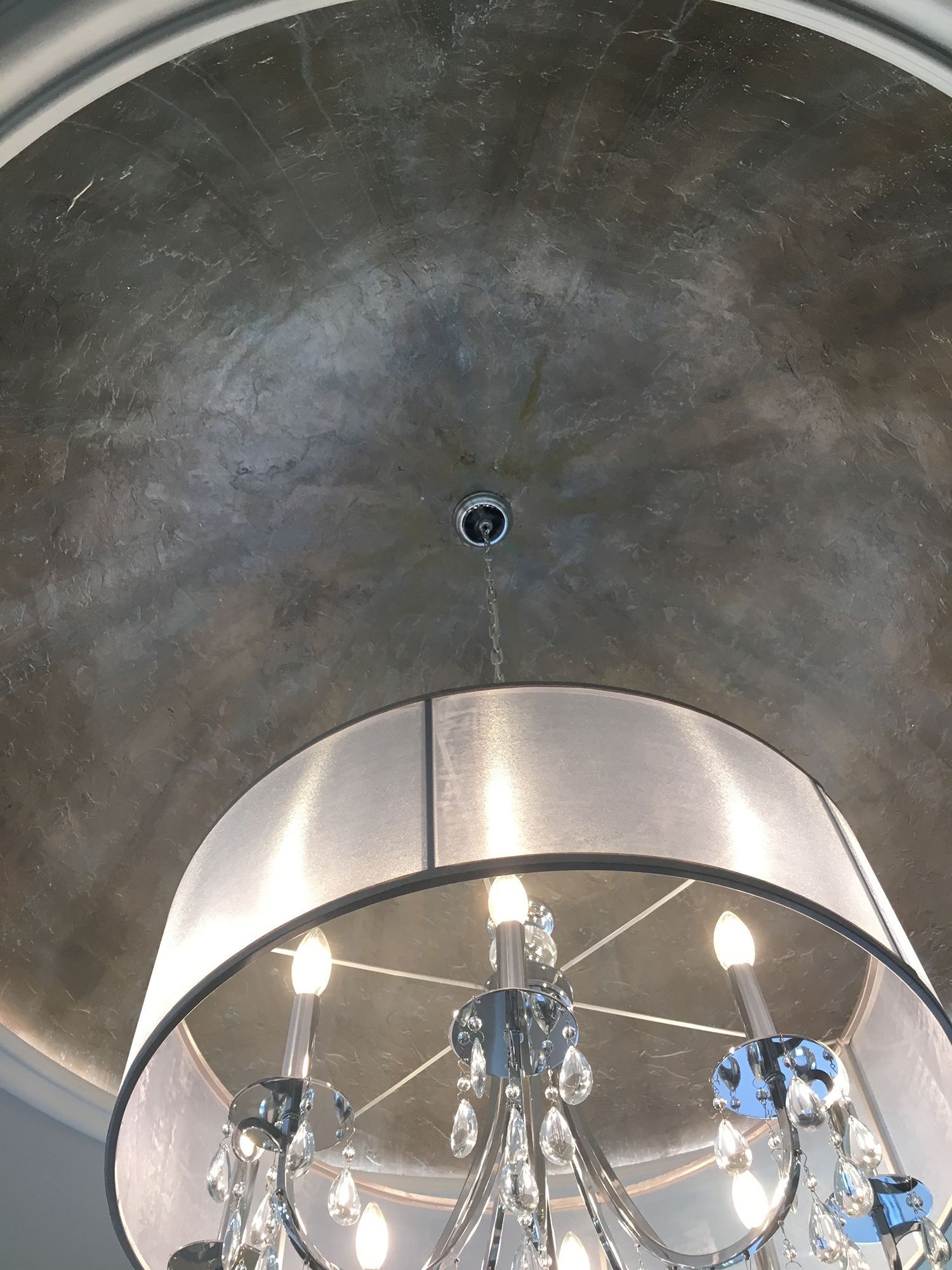 Silver-painted domed ceiling with chandelier featuring crystals and white shade.