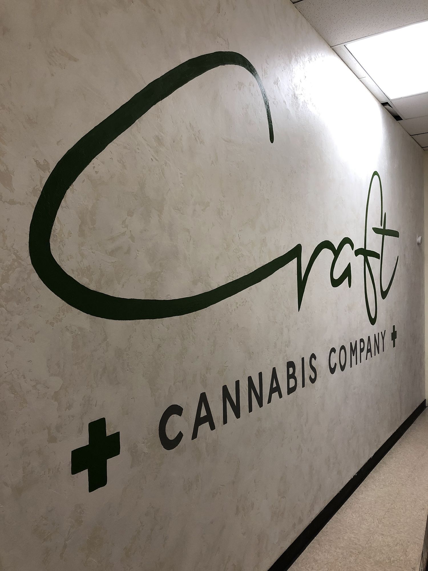 Craft Cannabis Company logo on a textured white wall.
