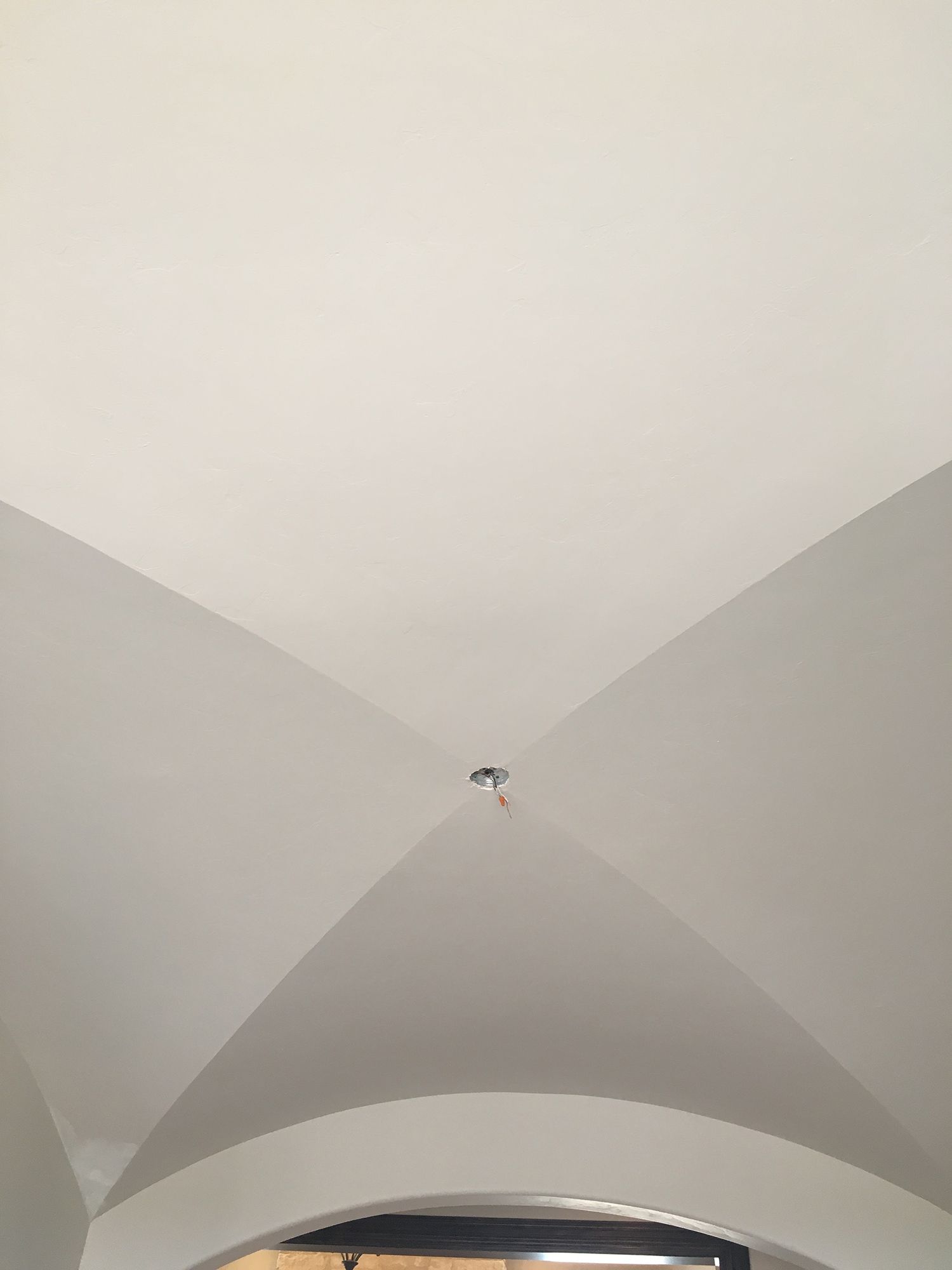 White arched ceiling with a central light fixture.