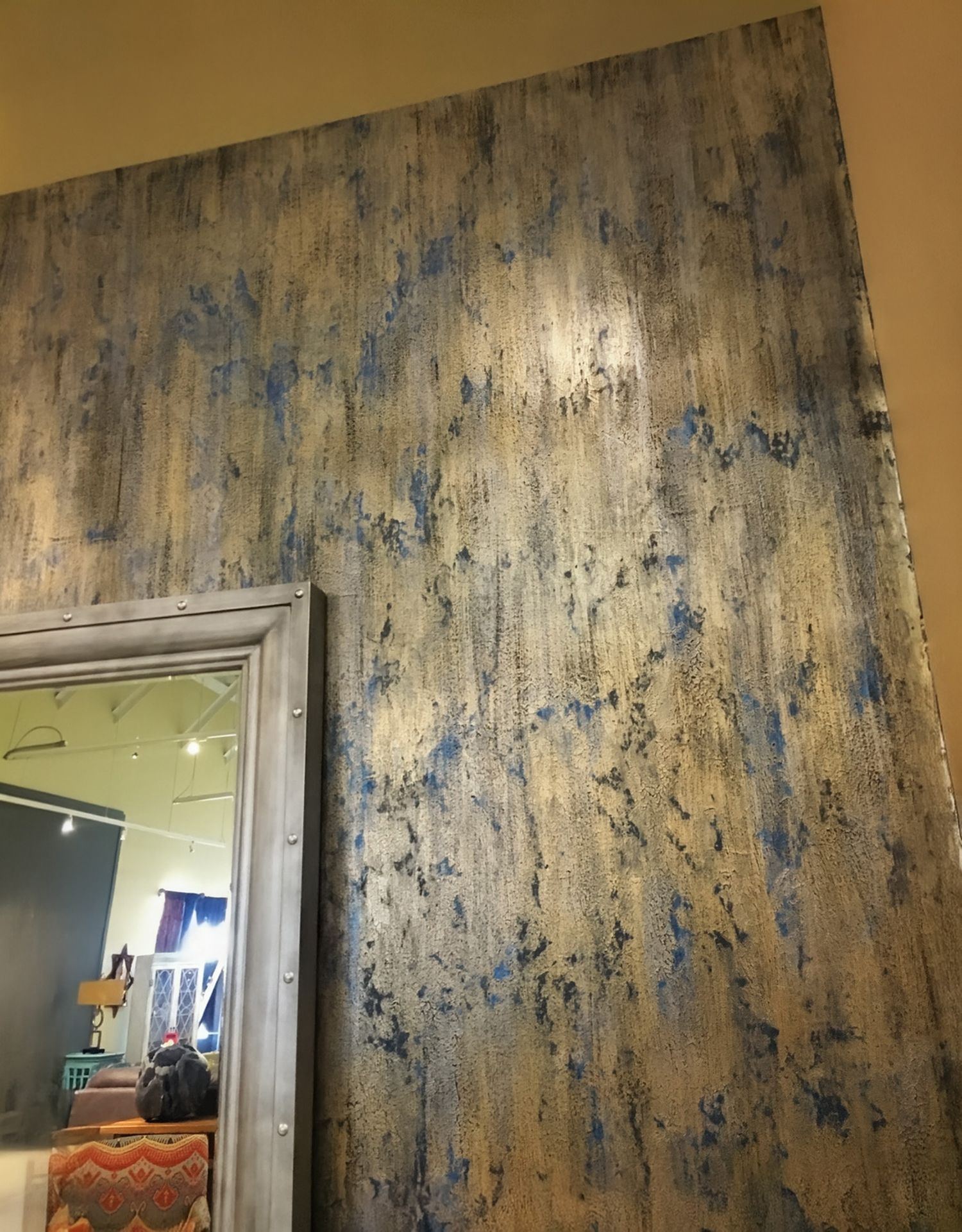 Textured wall with gold, blue, and silver streaks. A grey-framed doorway is on the left.