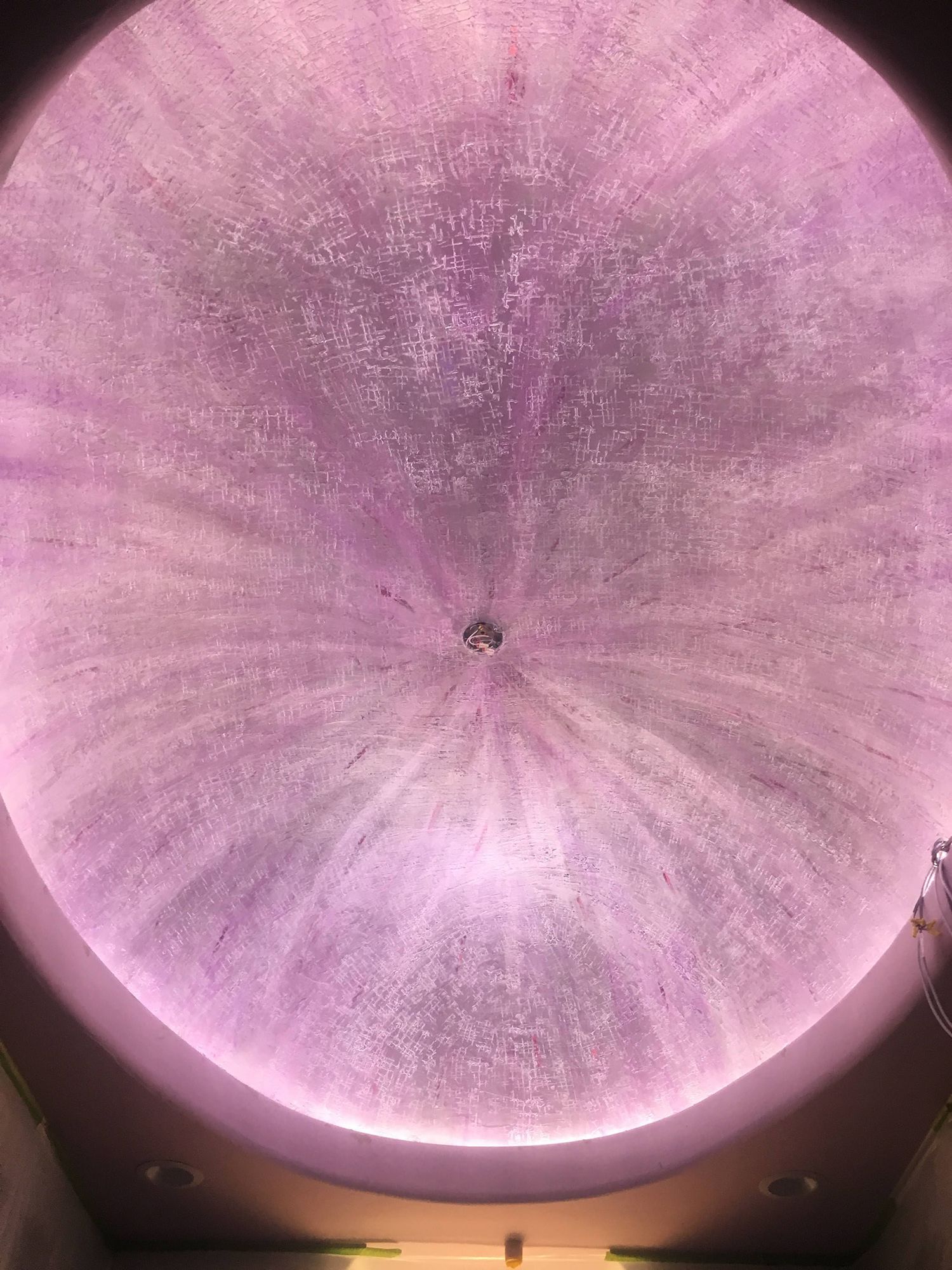 Purple, circular ceiling with radial light pattern, small light fixture in center.