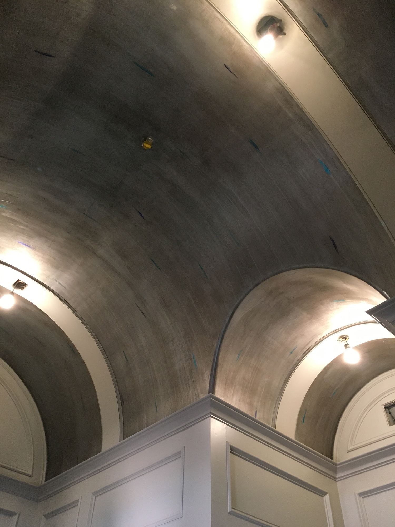 Arched ceiling with gray paint, white trim, and recessed lights.