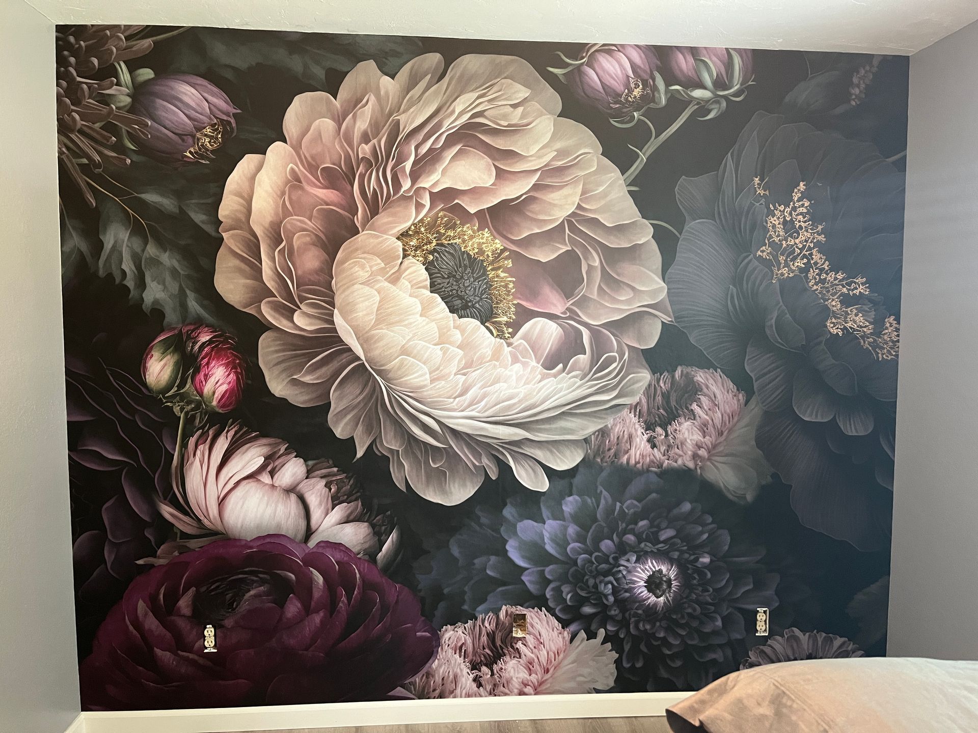 Floral mural featuring large, dark flowers in shades of purple and cream.
