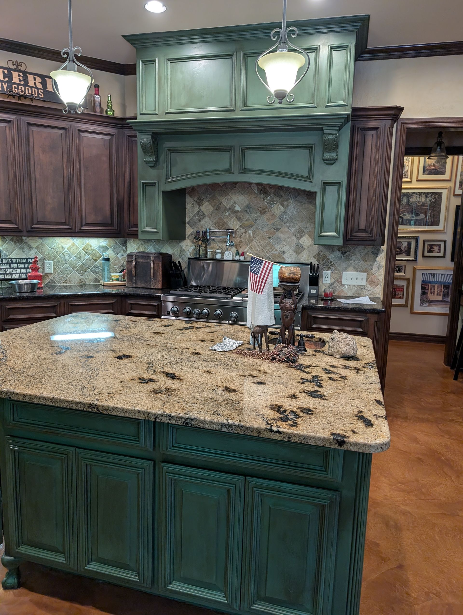 Green and brown kitchen with island and range hood. Cabinets, countertops and appliances.