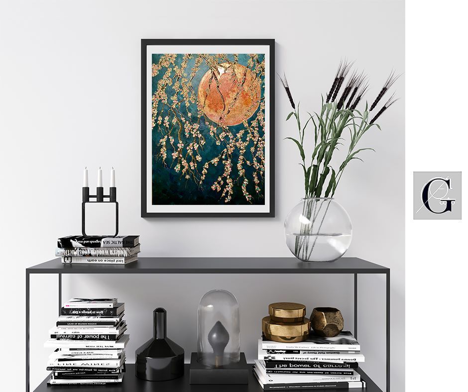 Black framed artwork, console table with books, vase with flowers, and decorative items against a white wall.