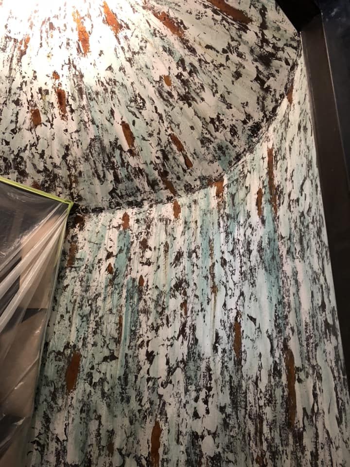 Textured walls with a distressed paint effect in white, brown, and teal.