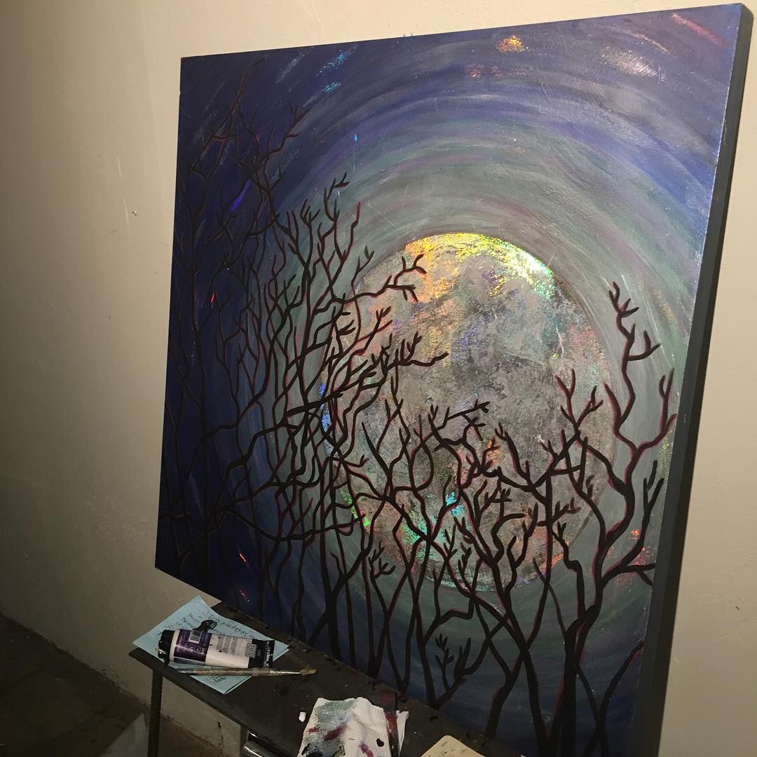 Painting of moon behind silhouetted trees with blue and purple background.