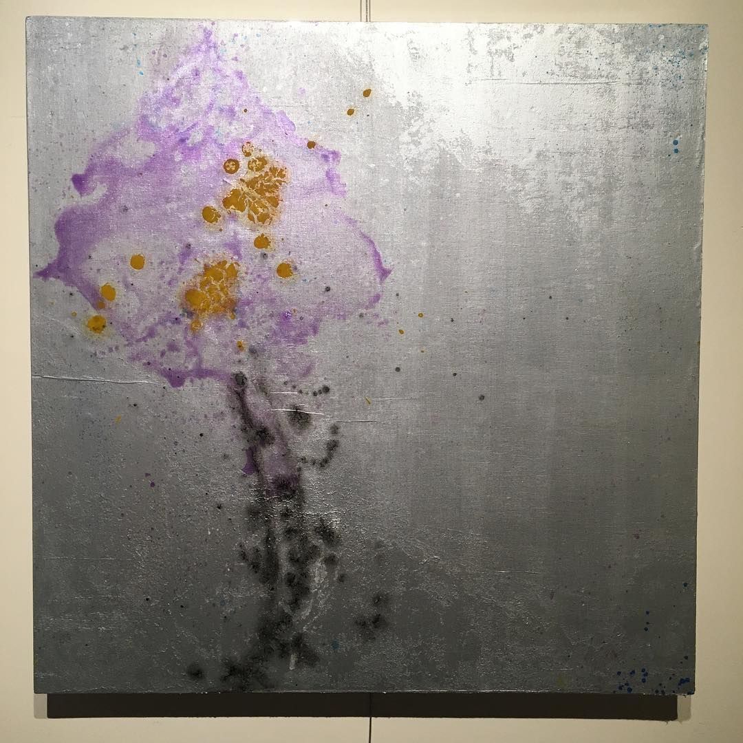 Purple and gold paint splatter on a silver square.