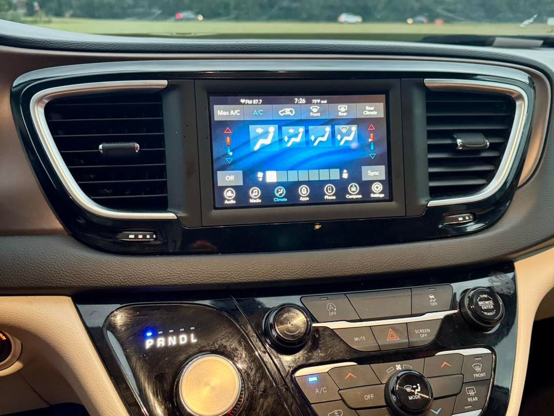 Dashboard of a Chrysler Pacifica with a screen displaying climate controls.