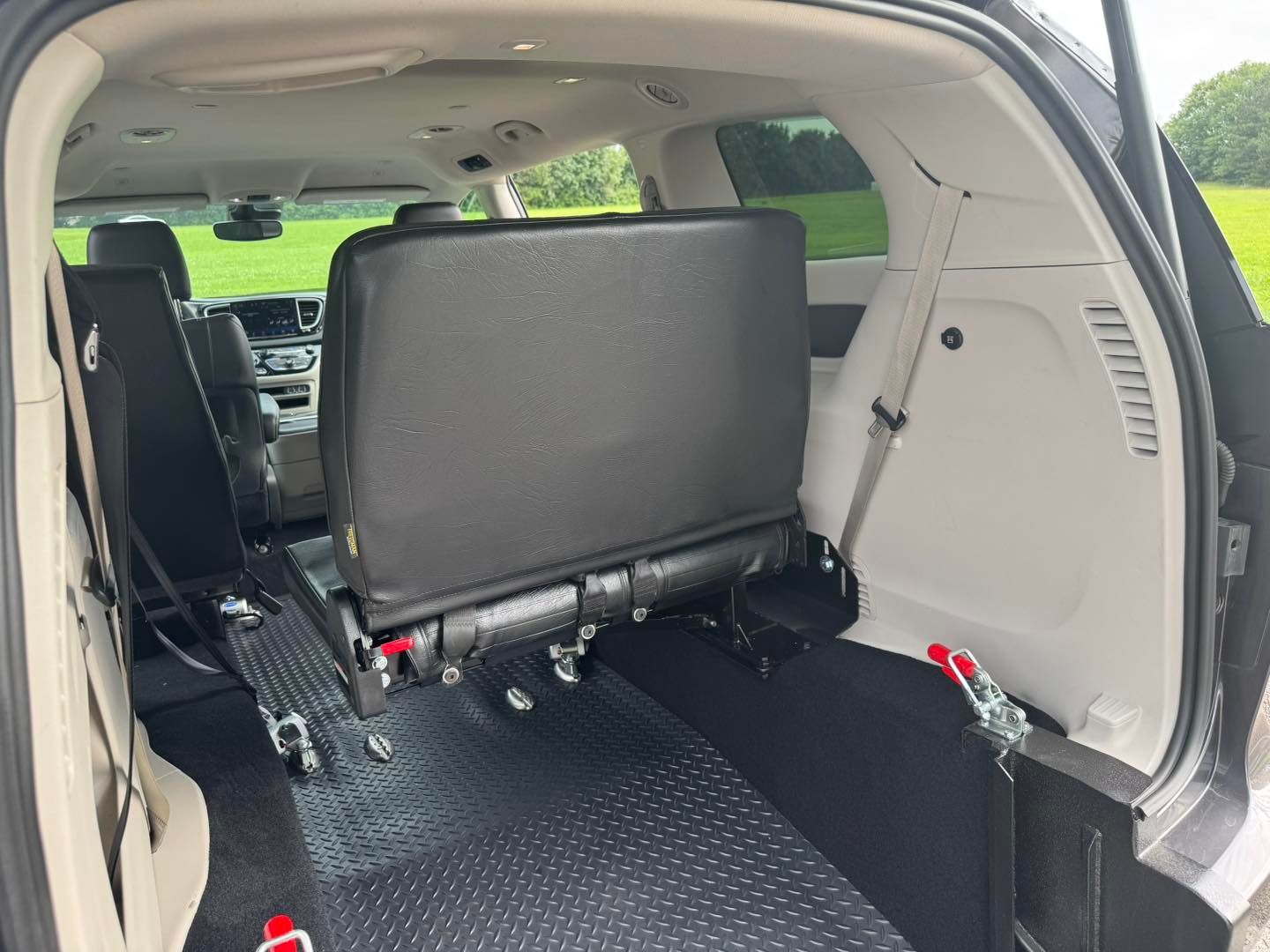 Interior view of a handicap-accessible van with rear seating and wheelchair tie-downs.